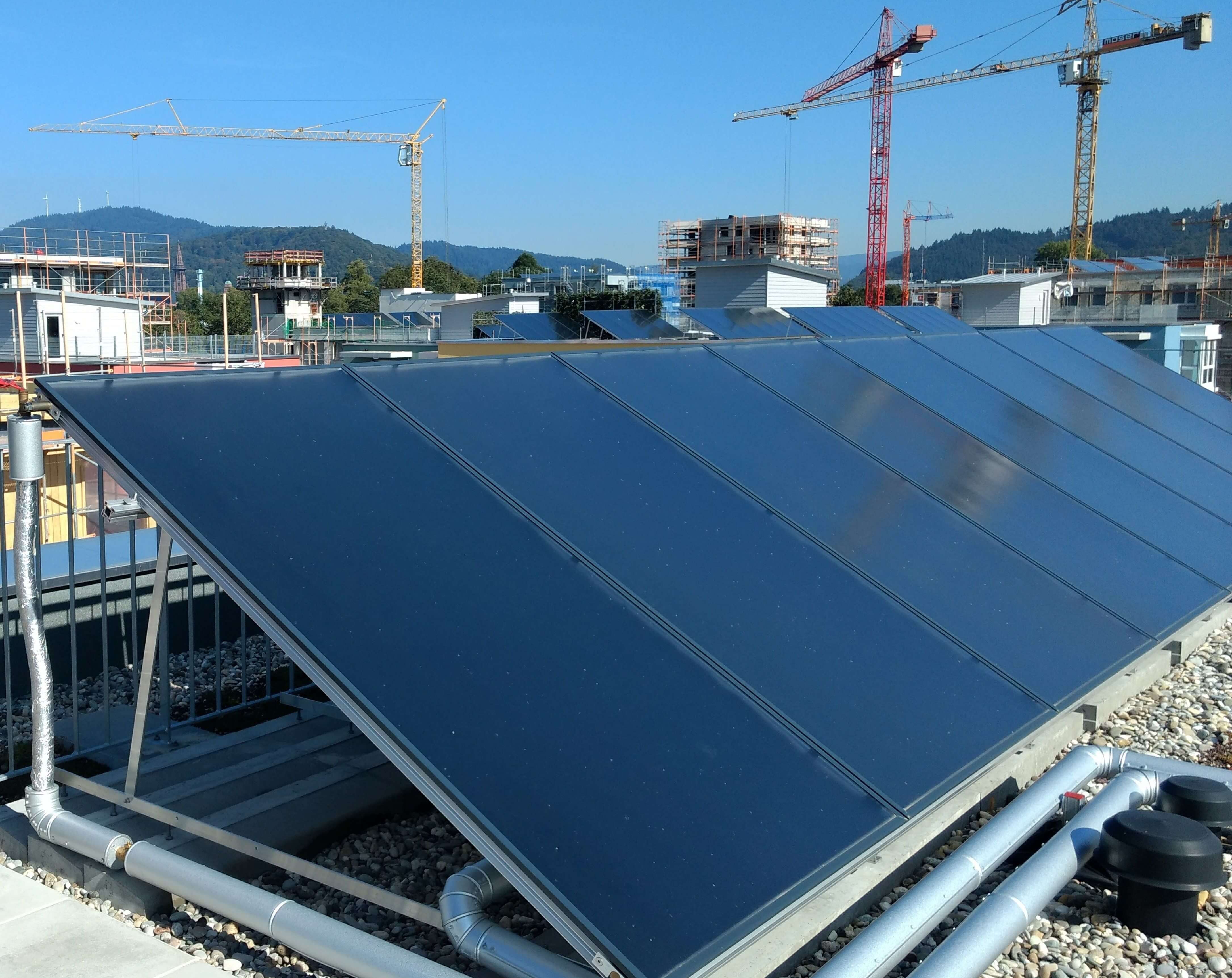 Reihe mit thermischen Solarkollektoren auf einem Flachdach im Baugebiet Freiburg-Gutleutmatten