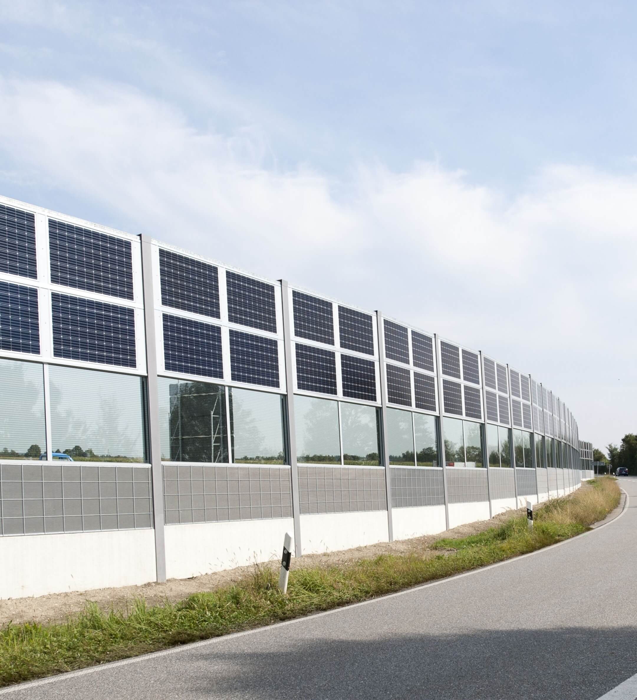 Massive Lärmschutzwand mit PV-Modulen