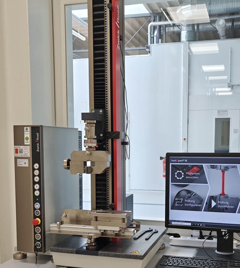 Linearachsen-Prüfmaschine zur mechanischen Charakterisierung von Batteriematerialien, aufgestellt im Trockenraum.