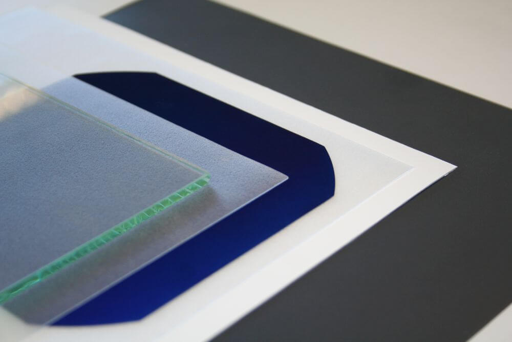 Die verschiedenen Materialien eines Solarmoduls, von dem Frontglas über die Solarzelle mit den Klebefolien bis zu der weißen Rückseitenfolie.