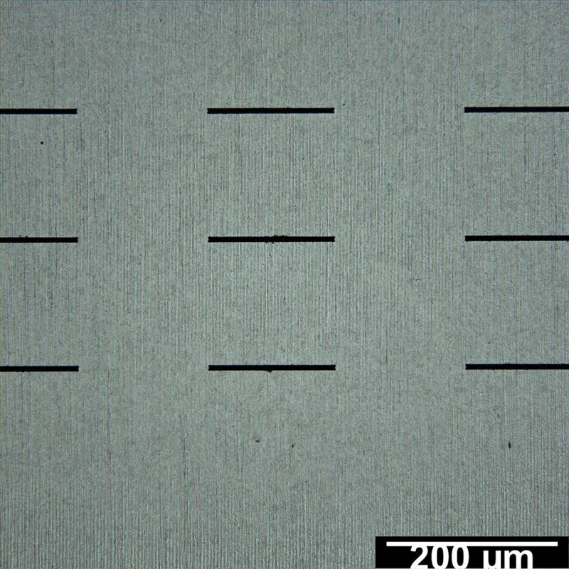 Präzise laserstrukturierte Öffnungen in einer Metallfolien-Schablone.