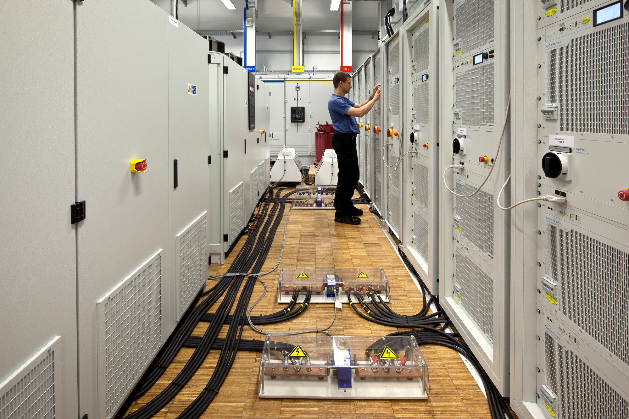 View of engineer working at the test setup in the TestLab Power Electronics of Fraunhofer ISE: PV array simulator (right) and device under test (left). 