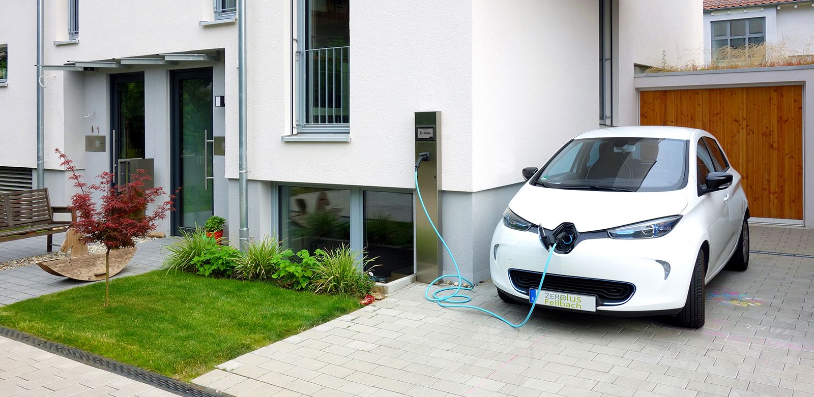 An electric vehicle is charged with photovoltaic power from the roof of the house using a charging station.