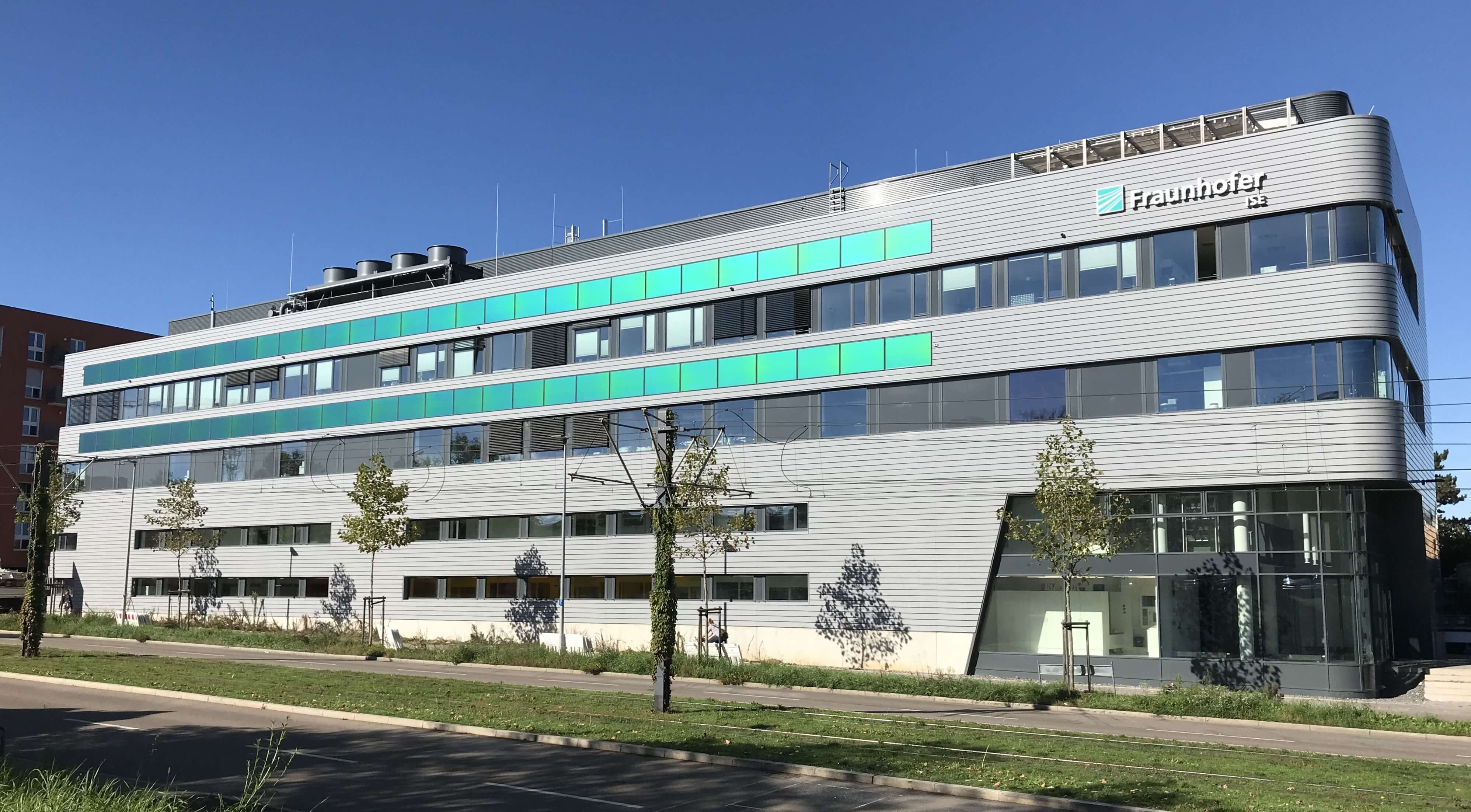The Center for Highly Efficient Solar Cells at Fraunhofer ISE in Freiburg, Germany, with MorphoColor® modules (green color stripes) inserted into a curtain-type, rear-ventilated facade.