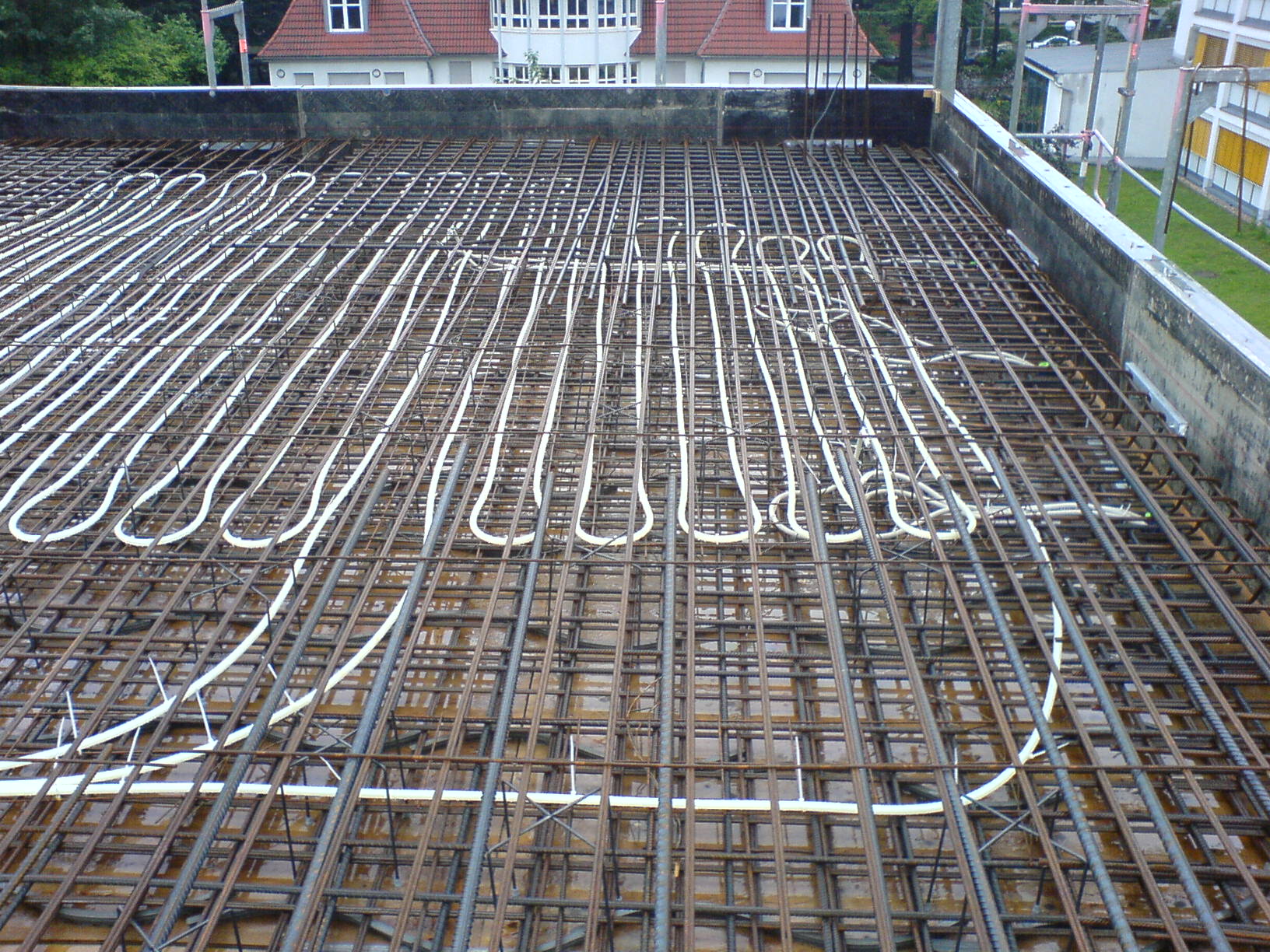 Laying piping in the ceiling when installing a concrete core tempering system.